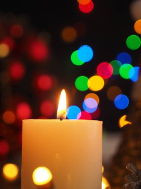 Bulanık Noel ışıkları ve güzel romantik Noel arkaplanı ile yanan bir mum.