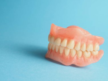 Metnin veya ürünün için alanı olan mavi bir arkaplanda takma dişler