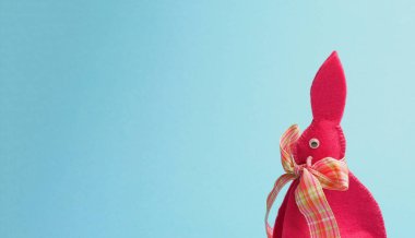 Paskalya kutlamalarınız ya da ürün resimleriniz için mavi kağıt arkaplanda pembe Paskalya tavşanı