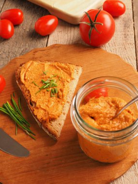 Frenk soğanı ve sağlıklı gıda konseptiyle süslenmiş kırsal heceli ekmeğe yayılmış organik vejetaryen domates.