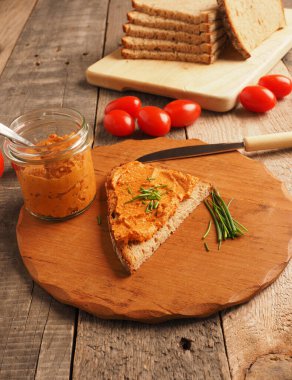 Frenk soğanı ve sağlıklı gıda konseptiyle süslenmiş kırsal heceli ekmeğe yayılmış organik vejetaryen domates.