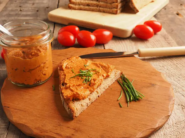 Frenk soğanı ve sağlıklı gıda konseptiyle süslenmiş kırsal heceli ekmeğe yayılmış organik vejetaryen domates.
