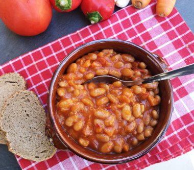 Ceramic bowl of baked beans with tomato sauce on the table  clipart