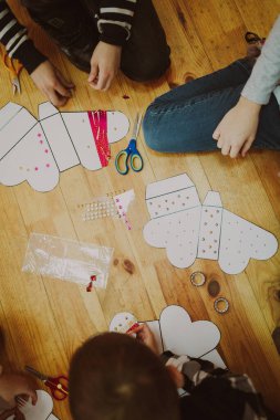 Çocuklar el işleri ve oyuncaklar yapar. Yukarıdan bak. Yaratıcı aksesuarları olan bir işyeri çizimi. Sanatsal araçlar.