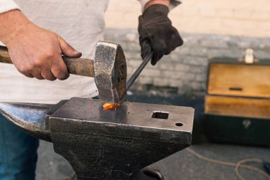 Blacksmith manually forging the molten metal clipart