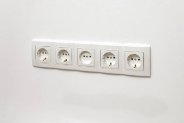 Beyaz duvar prizi beyaz duvara yerleştirilmiş, yan görünüşte..