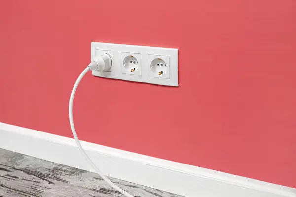 Біла Потрійна Розетка Встановлена Рожевій Стіні Вставленою Білою Електричною Вилкою — стокове фото