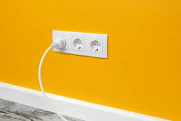 Біла Потрійна Розетка Встановлена Жовтій Стіні Вставленою Білою Електричною Вилкою — стокове фото