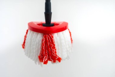 Kırmızı ve beyaz renklerin yer aldığı beyaz bir duvara asılı bir paspas başlığı.