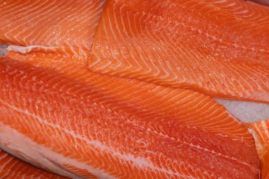 Balık pazarında taze somon filetosunun zengin dokusu ve rengi balık kalitesini vurguluyor..