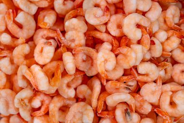 Donmuş karides yığınının yakın plan çekimi deniz ürünlerinin buzlu dokusunu ve detaylarını gözler önüne seriyor..