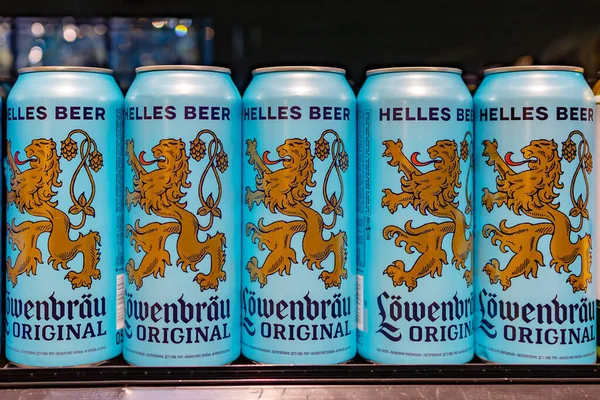 31 Ocak 2024 'te Kyiv' de bir mağaza rafında, kalın damgalı ve aslan amblemli bir sıra Lwenbru orijinal Helles bira kutusu.
