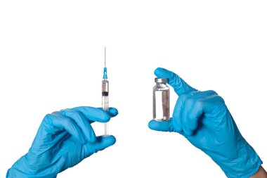 Tıbbi şırınga ve cam şişe tutan eldivenli eller, beyaz bir arka planda izole edilmiş..