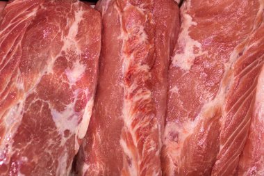 Kasap dükkanında sergilenen taze, çiğ domuz eti, etin dokusunu ve kalitesini ön plana çıkarıyor..