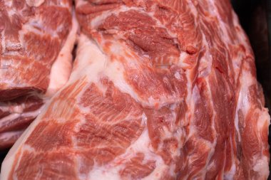 Kasap dükkanında sergilenen taze, çiğ domuz eti, etin dokusunu ve kalitesini ön plana çıkarıyor..