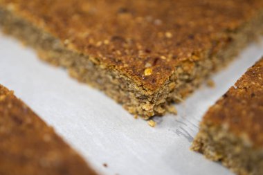 Kurumuş meyve ve fındık parçalarıyla yeni hazırlanmış müsli barın yakın çekim görüntüsü, gösterişli doku ve malzemeler.