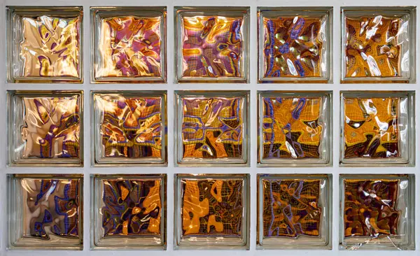 Färgglada Reflektioner Och Förvrängningar Genom Ett Rutnät Glasblocksfönster Vilket Skapar Royaltyfria Stockbilder