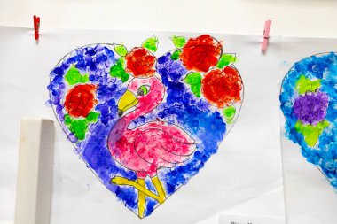 A vibrant drawing of a pink flamingo surrounded by colorful flowers, ideal for showcasing children's artwork, creativity, and classroom projects.