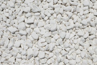 Beyaz çakıl taşlarının yakın plan görüntüsü pürüzsüz ve temiz bir doku yaratıyor, bahçe yolları ve dekoratif peyzaj için ideal..