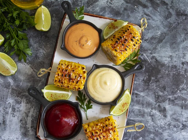 stock image grilled yellow head corn with spices lime close up white red orange sauce portion