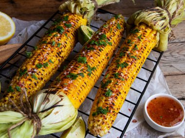 Üç baş sarı mısır ızgara limon baharatlı, beyaz turuncu kırmızı sos, köy usulü.