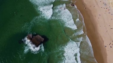4K hava manzaralı okyanus dalgaları kayalık uçurumlar kumlu sahil, Portekiz Hava Aracı Videosu. 20 Nisan 2023 