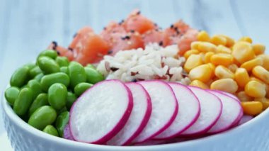 Somon, pirinç, edamame fasulyesi, sarı mısır, turp ve masada daireler çiziyor. Sağlıklı yemek, Asya çiğ yemeği. Geleneksel Hawaii çiğ balık salatası. Japon yemeği..