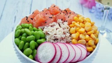 Somon, pirinç, edamame fasulyesi, sarı mısır, turp ve masada daireler çiziyor. Sağlıklı yemek, Asya çiğ yemeği. Geleneksel Hawaii çiğ balık salatası. Japon yemeği..