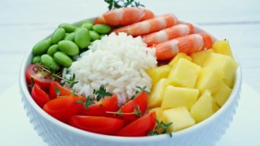 Karides, karides, pilav, edamame fasulyesi, mango, domates, masanın üstünde daireler çizen bir kase. Sağlıklı yemek..