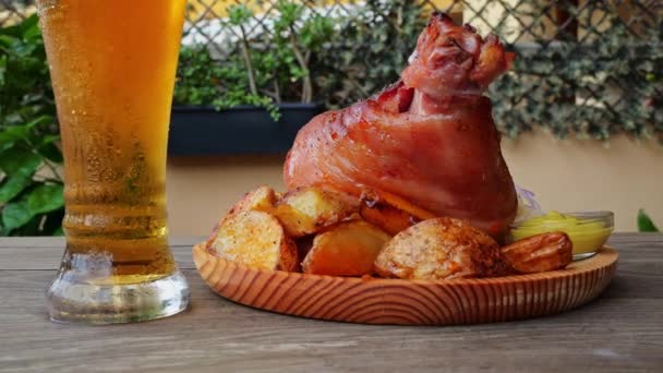 Schweinshaxe Mit Kartoffeln Sauerkraut Und Bier Rotieren Auf Einer Holzoberfläche — Stockvideo