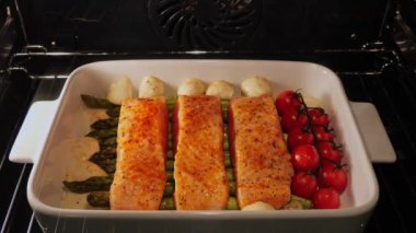 Domatesli somon fileto, kuşkonmaz ve fırında mozzarella peyniri pişirme işlemi. Kapatın. Zaman aşımı