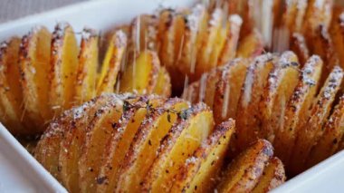 Fırında pişirilmiş hasselback patatesleri. Parmesan peyniri serpiştirilmiş. Kapatın. Yavaş çekim