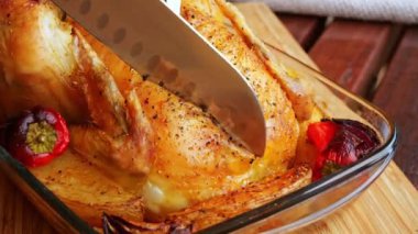 Sulu altın fırınlanmış tavuğu keserken yakın çekim