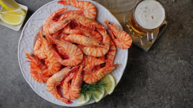 Tabakta dönen kaplan karidesi. Bir bardak bira. Üst görünüm
