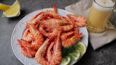 Tabakta pişmiş kaplan karidesi. Bira bardağa dökülüyor.. 