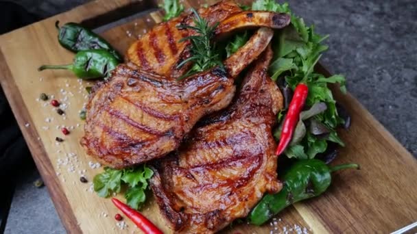 羊排猪排在木制切菜板上烤新鲜沙拉轮流 腰围在肋骨上 顶部视图 — 图库视频影像