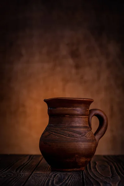 粘土壶在一张木制桌子上深色的背景上 — 图库照片