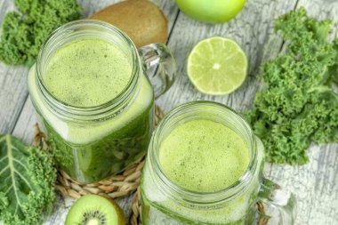 Smoothie in mugs of green cabbage, kiwi, lime and apple