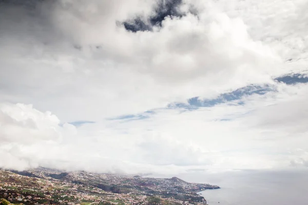 丘の斜面に家を建てるとポルトガルのマデイラ山の雲の上の印象的な景色 — ストック写真