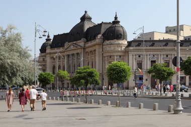 BUCHAREST, ROMANIA - 24 Haziran 2023: Revolutiei Meydanı 'nda (Piata Revolutiei) Kral I. Carol' un binicilik anıtı ile Merkez Üniversitesi Kütüphanesi (Calea Victoriei)