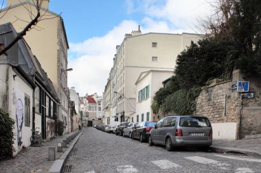 Paris, Fransa - 3 Şubat 2019: Paris 'in Montmartre semtinin eski kaldırım taşı caddelerinin manzarası, Paris' in Montmartre semtinin sıcacık dar caddesi