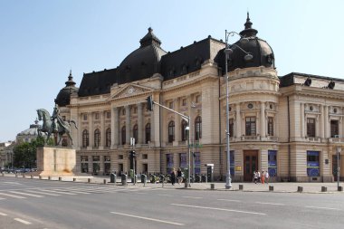 BUCHAREST, ROMANIA - 24 Haziran 2023: Revolutiei Meydanı 'nda (Piata Revolutiei) Kral I. Carol' un binicilik anıtı ile Merkez Üniversitesi Kütüphanesi (Calea Victoriei)