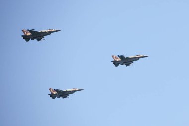 TEL AVIV, ISRAEL - April 15, 2021: Israeli Air Force F-16 planes fly in formation over the Mediterranean Sea as seen from a Tel Aviv beach. Tel Aviv Air Show dedicated to Israel's 2021 Independence Day clipart