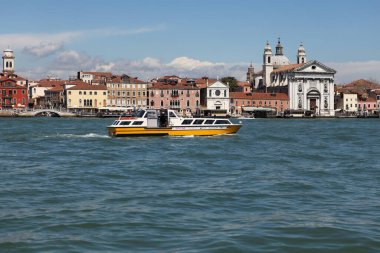 Venedik, İtalya - 27 Nisan 2019: Vaporetto olarak da bilinen bir su otobüsü, St. Mark 's Campanile' den geçerken Venedik lagününden geçiyor..
