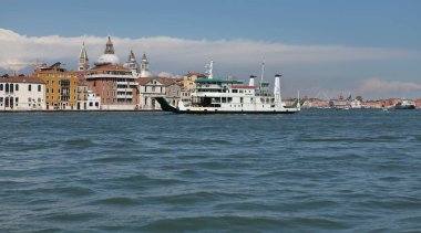 Venedik, İtalya - 27 Nisan 2019: Venedik 'in pitoresk mimarisinin yanından geçen bir feribot Büyük Kanal boyunca seyahat ediyor.
