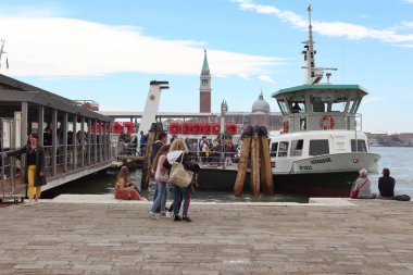 Venedik, İtalya - 30 Nisan 2019: İnsanlar arka planda Campanile di San Giorgio ile Vaporetto adlı Venedik su otobüsüne biniyorlar..