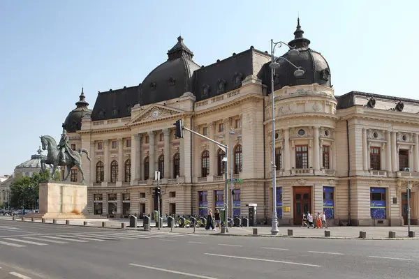 BUCHAREST, ROMANIA - 24 Haziran 2023: Revolutiei Meydanı 'nda (Piata Revolutiei) Kral I. Carol' un binicilik anıtı ile Merkez Üniversitesi Kütüphanesi (Calea Victoriei)