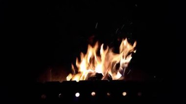 Close-up, flames from fire. Late evening. fire burns in barbecue, logs burn, before cooking on coals. Sparks from flame. outdoors