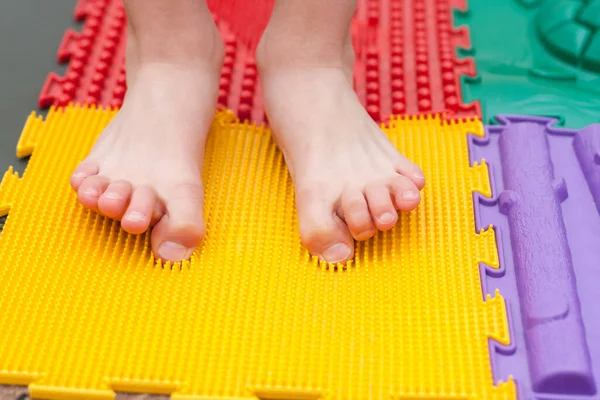 子供は自宅で整形外科マッサージマットの足の演習を行います 赤ちゃんの足のマッサージのための異なるテクスチャを模倣パズルマット 子供の平らな足とハルクスバルガスの予防 — ストック写真