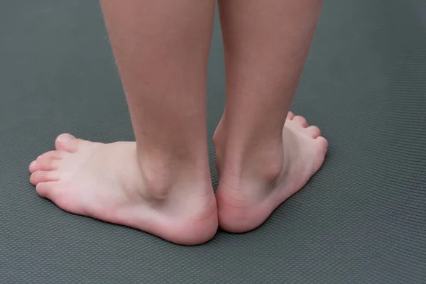 マットの上で裸足の子供 クローズアップの子供の足 バックビュー 未就学児の平らな足の予防 — ストック写真